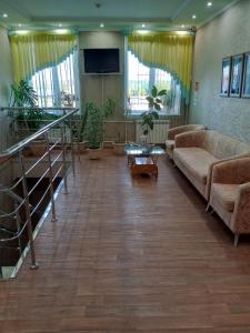 BelovoにあるInn Prazhechkaのソファと鉢植えの植物が備わる広いリビングルーム