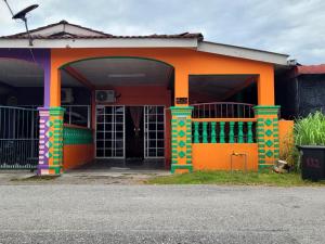 a brightly colored house with an orange at HAIDA'S HOMESTAY Seri Iskandar, Perak in Seri Iskandar