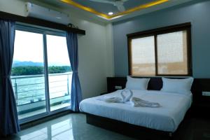 Un dormitorio con una cama con dos toallas blancas encima. en Sai Unity Boutique Stay, en Garudeshwar