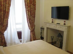 a bedroom with a bed and a television and a fireplace at La Magnolia in Orvieto