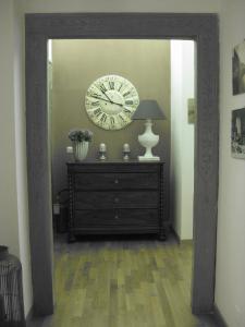 a large mirror in a room with a clock and a dresser at La Magnolia in Orvieto