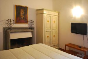 een slaapkamer met een bed, een tv en een open haard bij La Magnolia in Orvieto