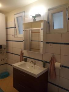 y baño con lavabo y espejo. en V4 Kilátóterasz Apartmanok Emelet en Nagymaros