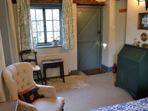 a living room with a green door and a chair at Riverside Lodge in Wyck Rissington