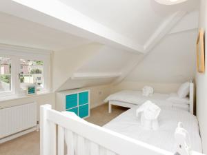 a white attic bedroom with two beds and a window at Hawkins in Dartmouth