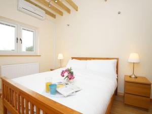 a bedroom with a bed with a book and flowers on it at Kentish Barn Retreat in Chilham