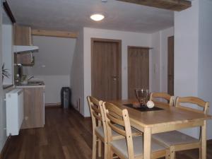 a kitchen and dining room with a wooden table and chairs at Houda Bouda - Penzion & Apartmány in Boží Dar