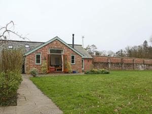 a brick house with a grass yard in front of it at The Bothy At Fordcombe in Speldhurst