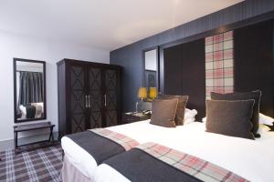 a bedroom with a large bed with a large headboard at Malmaison Aberdeen in Aberdeen