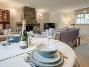 a living room with a table with a wine bottle at Summerhill Cottage HW7101 in Amroth