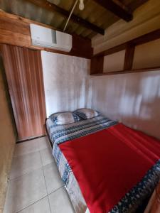 a bedroom with a bed with a red blanket at Hugo's relax home (Suite) in Ayangue