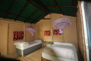 Zimmer mit 2 Betten und Sonnenschirmen an der Wand in der Unterkunft Wild Planet Eco Retreat in Bhurkīā