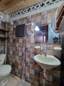a bathroom with a sink and a toilet at Hugo's relax home (Suite) in Ayangue