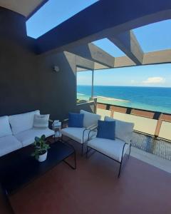 uma sala de estar com sofás e vista para o oceano em Attico Suite spiaggia Bari em Bari
