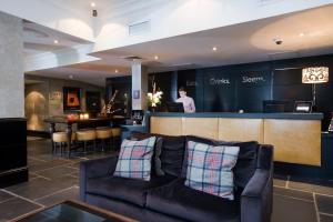 a living room with a couch and a bar at Malmaison Aberdeen in Aberdeen