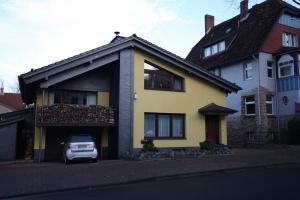 ein gelbes Haus mit einem davor geparkt in der Unterkunft Ferienwohnung Hintze in Bad Harzburg