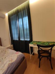 a bedroom with a bed and a table and a chair at Lux apartment, near metro Vasylkivska in Kyiv