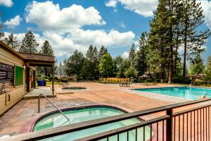 a hot tub on a deck next to a swimming pool at Tree Top Retreat in Bend