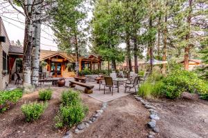 a patio with a table and chairs in the woods at Tree Top Retreat in Bend