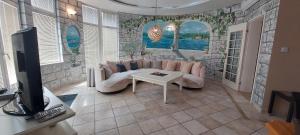a living room with a couch and a tv at Spa Resort Luxury Apartments in Budva