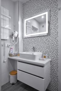 a white bathroom with a sink and a mirror at Weiss Estate by EstateAutomata in Burgas City