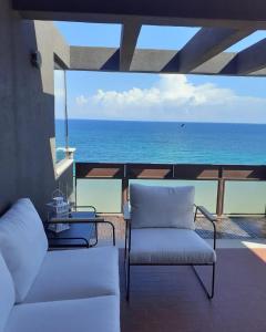 a balcony with two chairs and a view of the ocean at Attico Suite spiaggia Bari in Bari