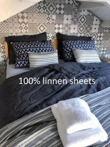a bed with black and white sheets and pillows at Houseboat apartment with water terrace, free parking, free bikes & fast wifi in Amsterdam