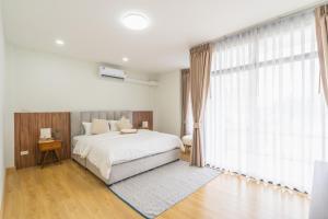 南奔The B Hostel的一间带床和大窗户的卧室