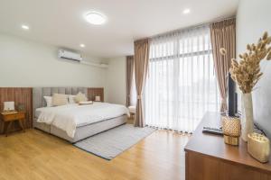 南奔The B Hostel的一间带床和大窗户的卧室