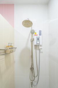 a shower with a shower head in a bathroom at The B Hostel in Lamphun