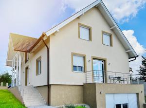 a white house with a balcony at Panoráma Apartman Mogyoród in Mogyoród