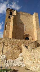 un bâtiment avec une tour au-dessus d'un mur en pierre dans l'établissement Apartamento Benabarre, Huesca, à Benabarre