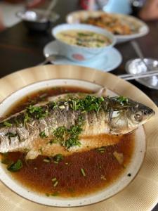 a plate of fish with soup on a table at 行者之家SUNFLOWER in Lumbini