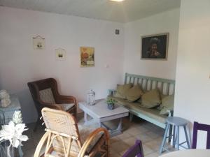 a living room with a couch and a table and chairs at Le gîte des Mégalithes in Le Bernard