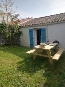 a picnic table in the yard of a house at Le gîte des Mégalithes in Le Bernard