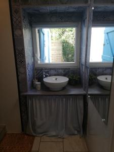a bathroom with two sinks and a window at Le gîte des Mégalithes in Le Bernard