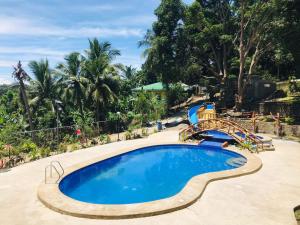 a pool with a slide and a water park at Alegria Hotel in Bauan