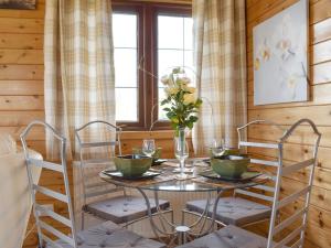 Otterford的住宿－Llama Lodge，一间带桌椅和窗户的用餐室