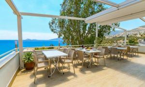 a patio with tables and chairs and a view of the ocean at KALAMAKİ FLATS in Kaş