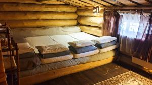 Habitación con cama en una cabaña de madera en Forest hut Stariy Prud, en Filippovichi