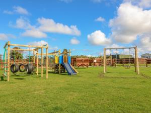 a playground with a slide and swings at The Lodge in Amlwch