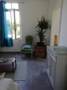 ein Wohnzimmer mit einem Stuhl und einem Fenster in der Unterkunft Maison in Hourtin