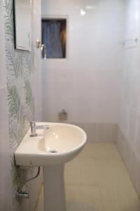 a white bathroom with a sink and a shower at JCT Houseboat in Alleppey