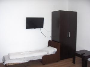 a bedroom with a cabinet and a tv on the wall at Krasteva House in Berkovitsa