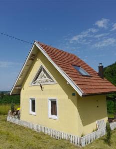 a small yellow house with a red roof at Vikendica za odmor Raduša in Tešanj