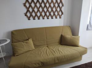 a brown couch with two pillows in a room at comfy condo Otopeni in Otopeni