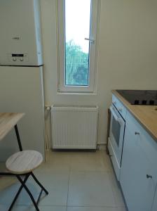 uma cozinha com um frigorífico, uma mesa e uma cadeira em comfy condo Otopeni em Otopeni