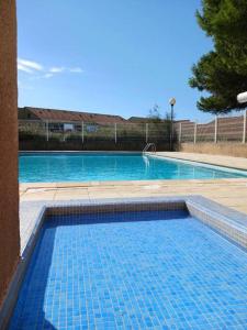 Una gran piscina con azulejos azules. en Chez Yamina, en Gruissan 19 fotos más