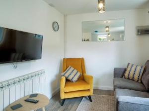 a living room with a chair and a tv at Coley Cottage in Wainfleet All Saints