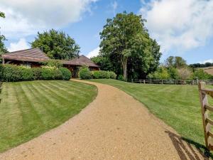 a dirt road leading to a house with a fence at Castlemans Stables West in Sedlescombe